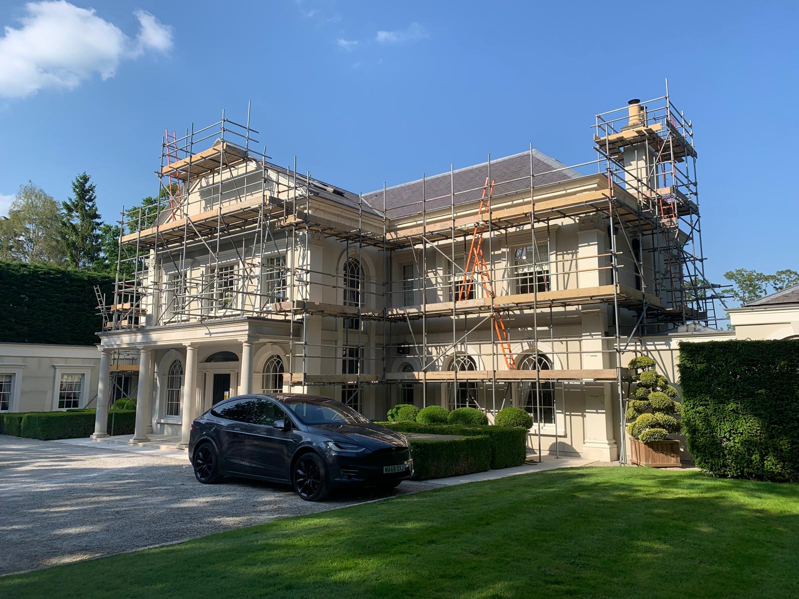 Period mansion re-roof with NPS scaffold and Tesla on the drive